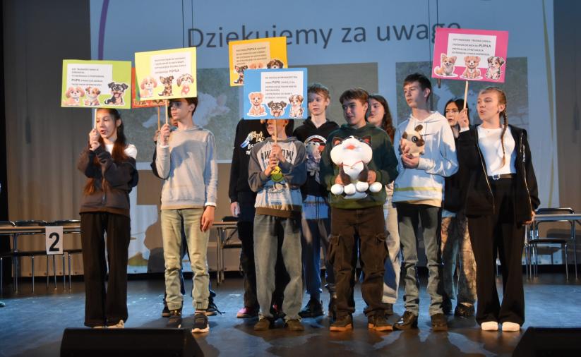 Występ drużyny dopingującej z SP3 w Dzierżoniowie. W rękach trzymają kolorowe plakaty. 