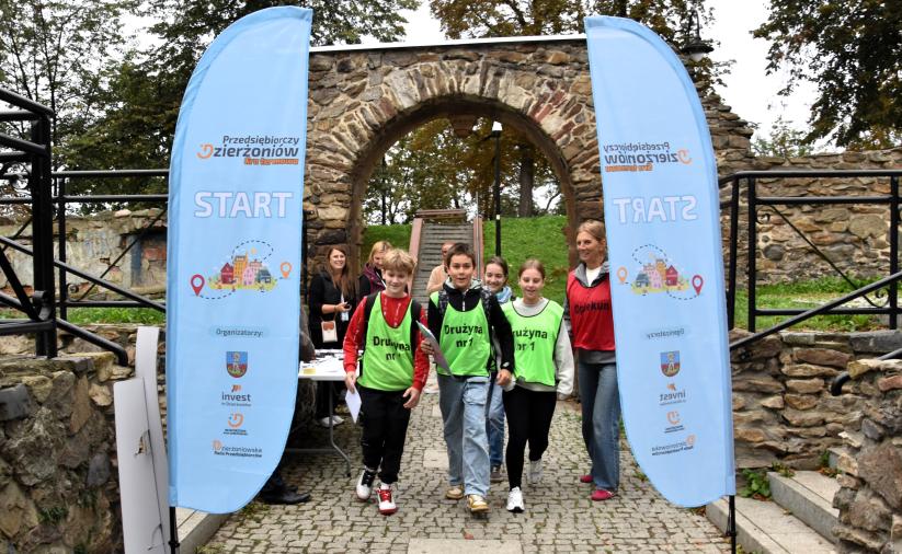 Start Gry Terenowej Przedsiębiorczy Dzierżoniów. Grupa uczniów przechodzi przez punkt.start.