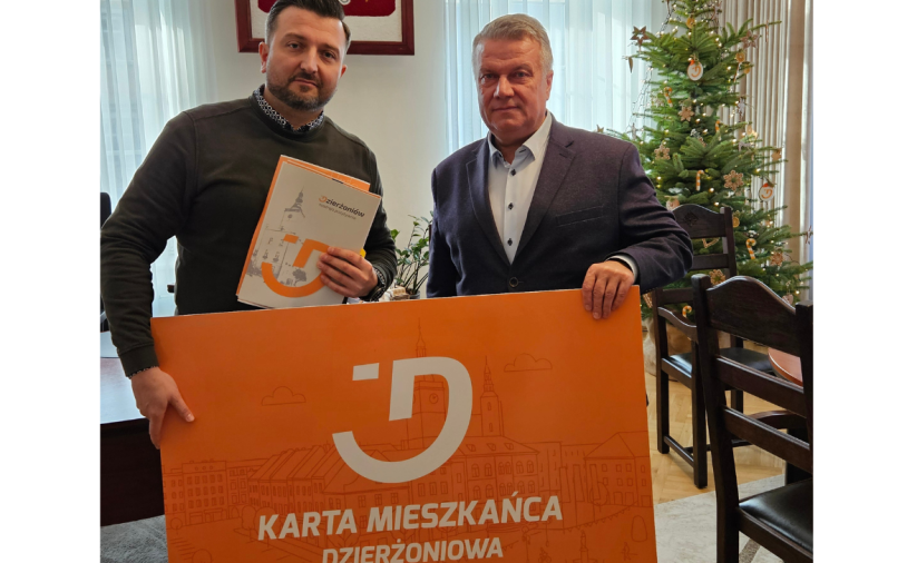 Dwie osoby trzymają pomarańczowy baner - Kartę Mieszkańca Dzierżoniowa