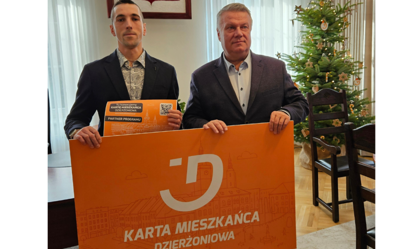 Dwie osoby trzymają pomarańczowy baner - Kartę Mieszkańca Dzi