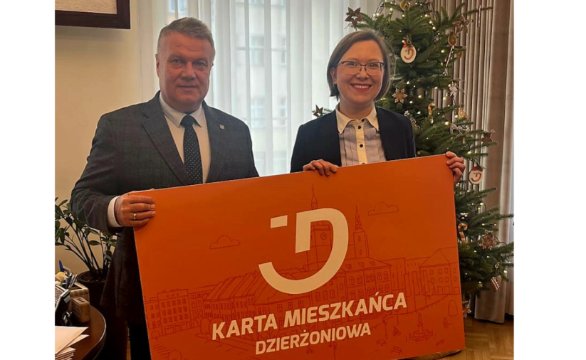 Dwie osoby trzymają pomarańczowy baner - Kartę Mieszkańca Dzierżoniowa