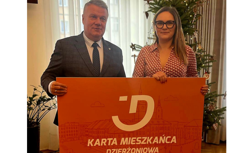 Dwie osoby trzymają pomarańczowy baner - Kartę Mieszkańca Dzierżoniowa