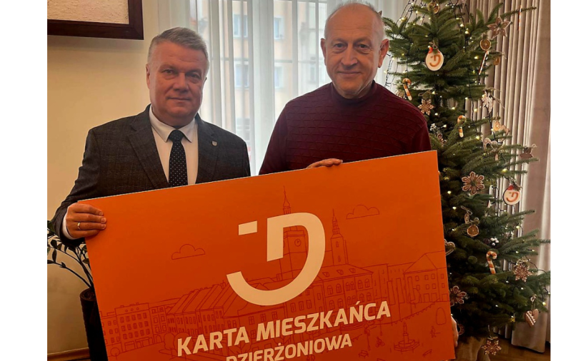 Dwie osoby trzymają pomarańczowy baner - Kartę Mieszkańca Dzierżoniowa