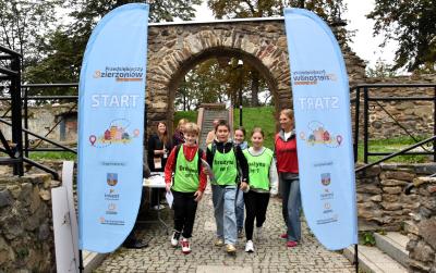 Start Gry Terenowej Przedsiębiorczy Dzierżoniów. Grupa uczniów przechodzi przez punkt.start.