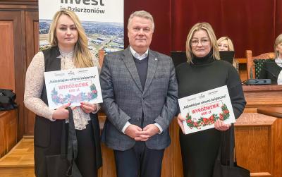 Dwie laureatki wyróżnienia z dyplomami oraz burmistrz miasta podczas wręczenia nagród.